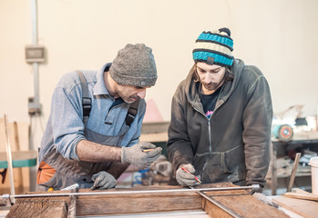 Construction Worker Using Tape Measure / Professional carpenter at work measuring wooden planks