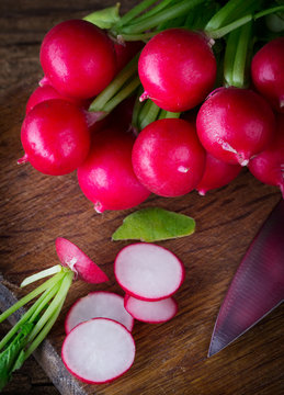 Radishes on kitchen board with knife
