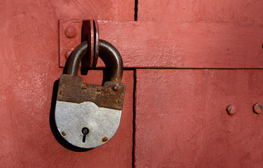 Closeup of old lock on red metal garage door