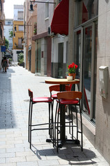Small cute cafe for threesome in downtown street in oldtown Blanes, Catalonia, Spain