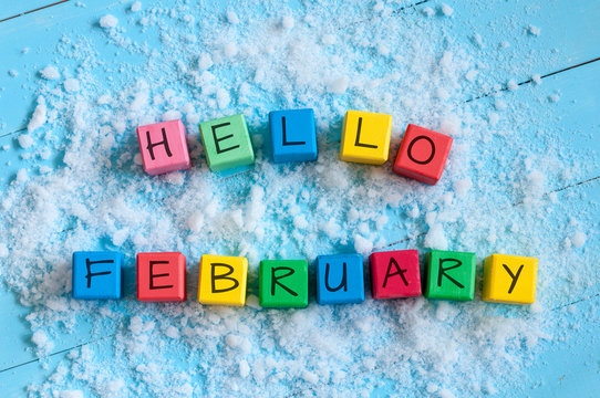 Hello February. Cube calendar for february on wooden surface with snow 