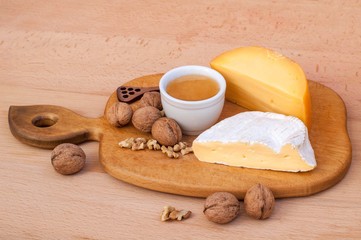 Cheese, walnuts, honey on a wooden table