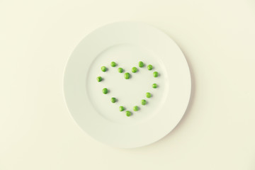 close up of plate with peas  in heart shape 