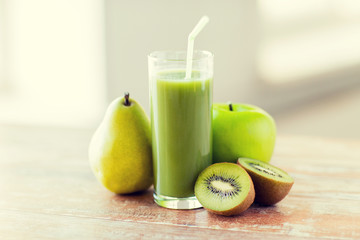 close up of fresh green juice and fruits on table