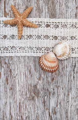 Shabby chic background with seashells and lace on the old wood