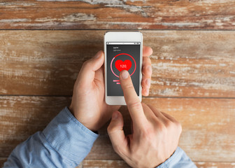 close up of male hands with smartphone on table