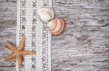 Fototapeta na wymiar Shabby chic background with seashells and lace on the old wood