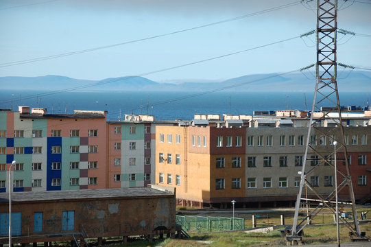 Apartment building block with hilly tundra coast in background