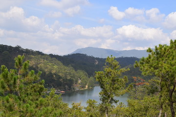 pine woods on the bank of the lake and the mountain on the another bank in Dalat, Vietnam
