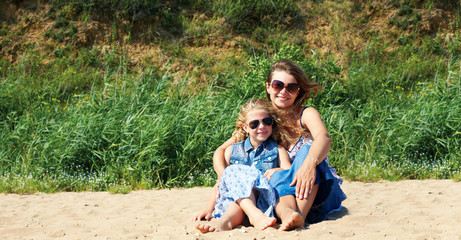  Cute little girl and her mother have a good time at the seaside