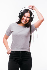 Nice brunette girl listen dancing to music with headphones on a white background