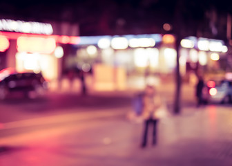 Blurred background, people walking at street at night in downtow