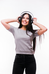 Nice brunette girl listen dancing to music with headphones on a white background