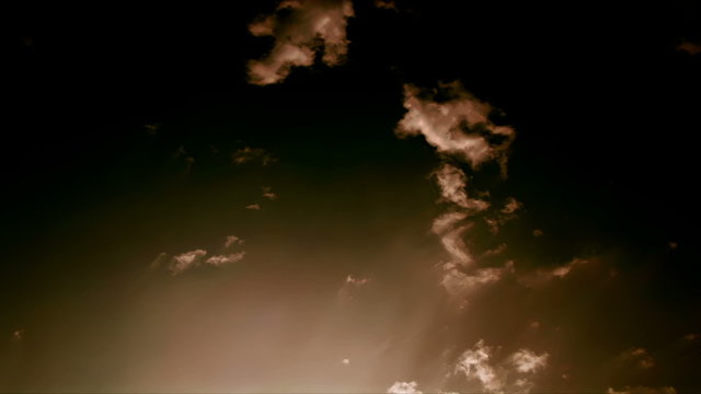 Fantastic Clouds 0204: Time lapse golden clouds travel across a dark sunsetting sky.