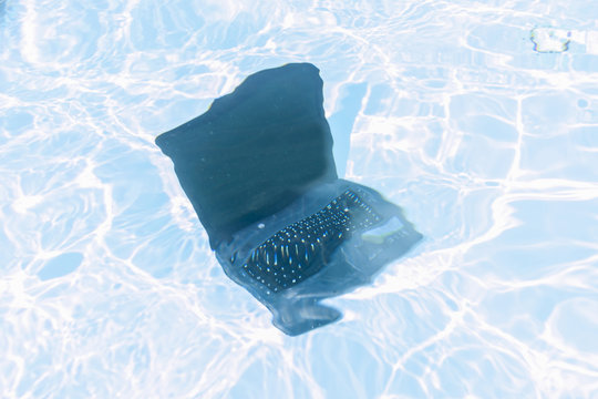 laptop thrown underwater in a swimming pool