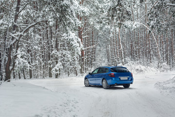 Winter landscape with road and blue car