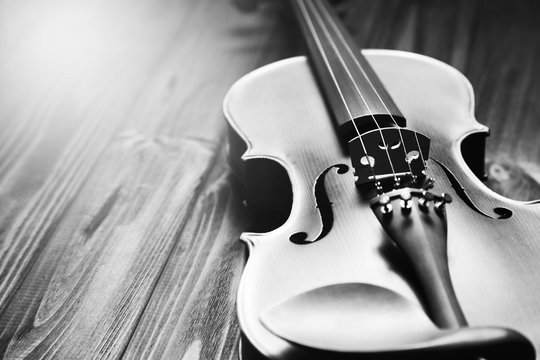 Old violin on wooden background.
