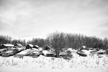 A junkyard of old vintage vehicles in black and white 