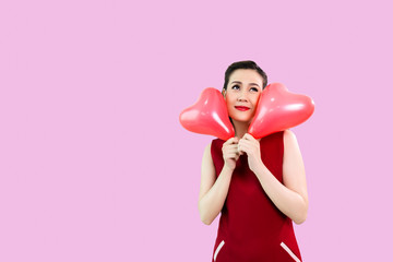 sexy asian young woman in red dress with hug heart-shaped balloons. Valentine's day on