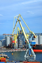 Fototapeta na wymiar Cargo crane, ship and grain dryer in port Odessa, Ukraine