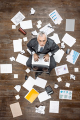 Top view photo of senior businessman on wooden floor