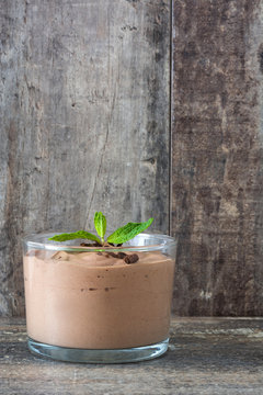Fresh chocolate mousse on a rustic wood table
