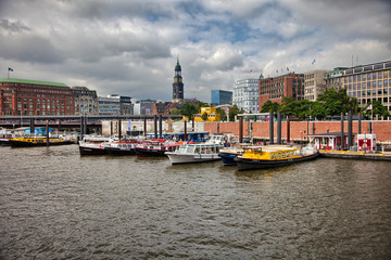Fototapeta premium Downtown Hamburg on a cloudy day. Tourist boats passing on the waterways.
