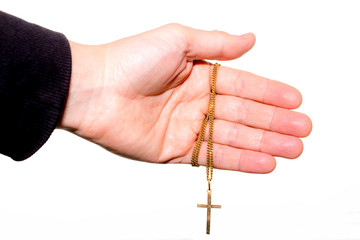 Hand holds a chain with gold crucifix