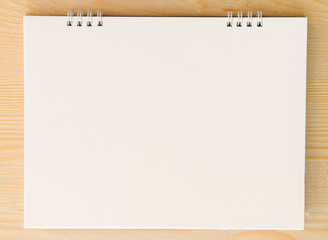 Blank paper sheet on bright wooden table.