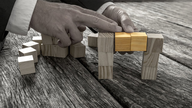 Closeup of businessman forming a bridge of small wooden blocks i