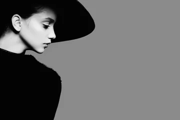 Foto op Plexiglas Portrait of beautiful girl in hat in profile, posing in studio, black and white photography © Yuliya Yafimik