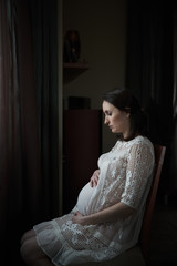Fototapeta premium Pregnant woman sitting on a chair