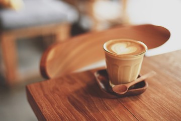 cup of coffee latte art on the wood desk