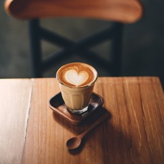 cup of coffee latte art on the wood desk
