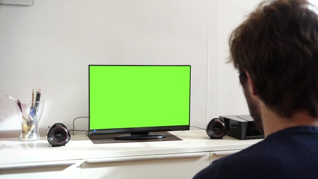 Young Man Watching Television Green Screen in Living Room. Young man watching television green screen alone at home - 1080p