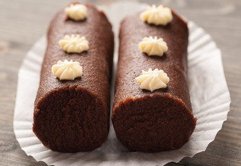 Two brown biscuit cakes on a white decorative paper