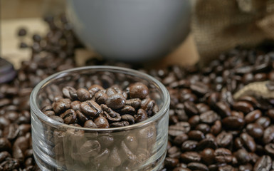 Roasted coffee beans / Roasted coffee beans in glass placed on a wooden floor.