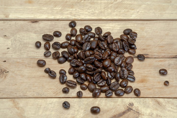 Roasted coffee beans / Roasted coffee beans placed on a wooden floor.