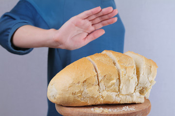 Gluten intolerance and diet concept. Woman refuses to eat white bread. Selective focus on bread