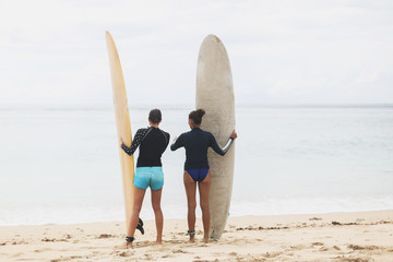 Fototapeta na wymiar Two girls surfers