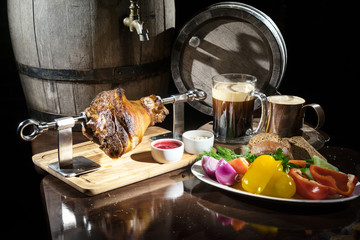 pork knuckle on the background of oak barrels with vegetables