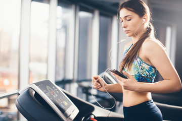 Woman on treadmill using her mobile phone