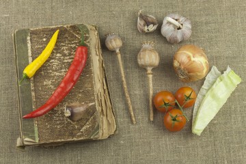 Chilies with an old recipe book. Vegetables ready for home cooking. Place for your text.
