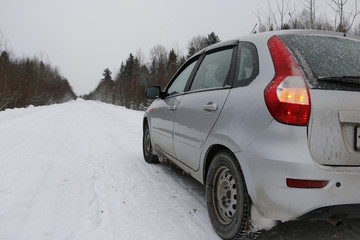 Fototapeta na wymiar Автомобиль на заснеженной дороге зимним днем