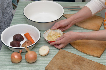 Woman hands putting bowl of sauerkraut on kitchen table.