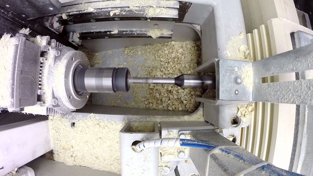 View of drill plunges into boards and shavings fly