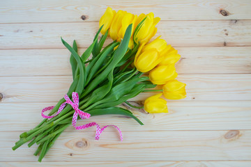 Yellow tulips on a wooden surface