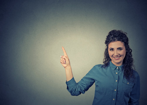 Attractive young woman pointing at blank copy space