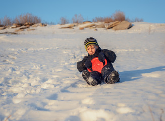 Fototapeta na wymiar Happy little boy having fun in winter snow