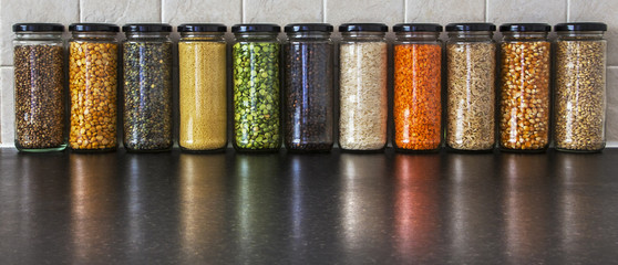 Health Food - variety of seeds and pulses in jars, with reflecti